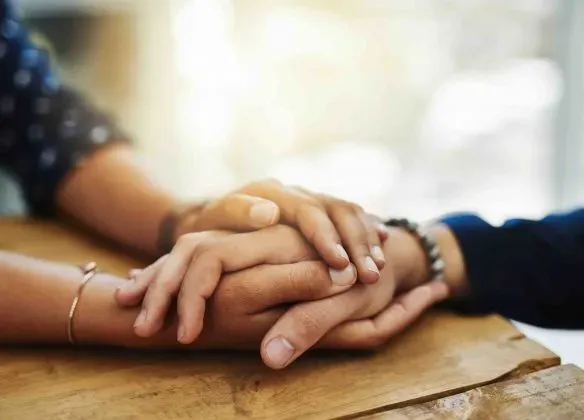 Mains serrées en signe de soutien, d'empathie et de réconfort durant le deuil.